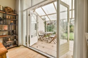 the inside of a house that is being used as a living room and dining area with sliding glass doors leading to an outdoor patio